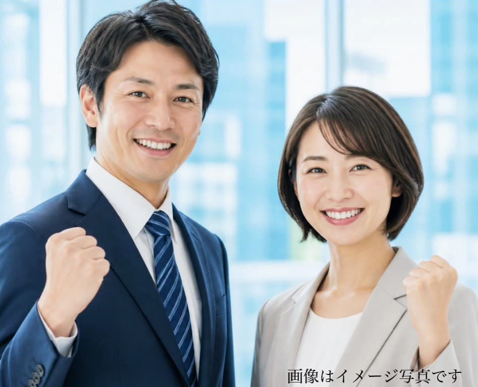 2名1組の丁寧な成婚サポートを表現するスーツ姿で笑顔でガッツポーズをする男性と女性のイメージ写真