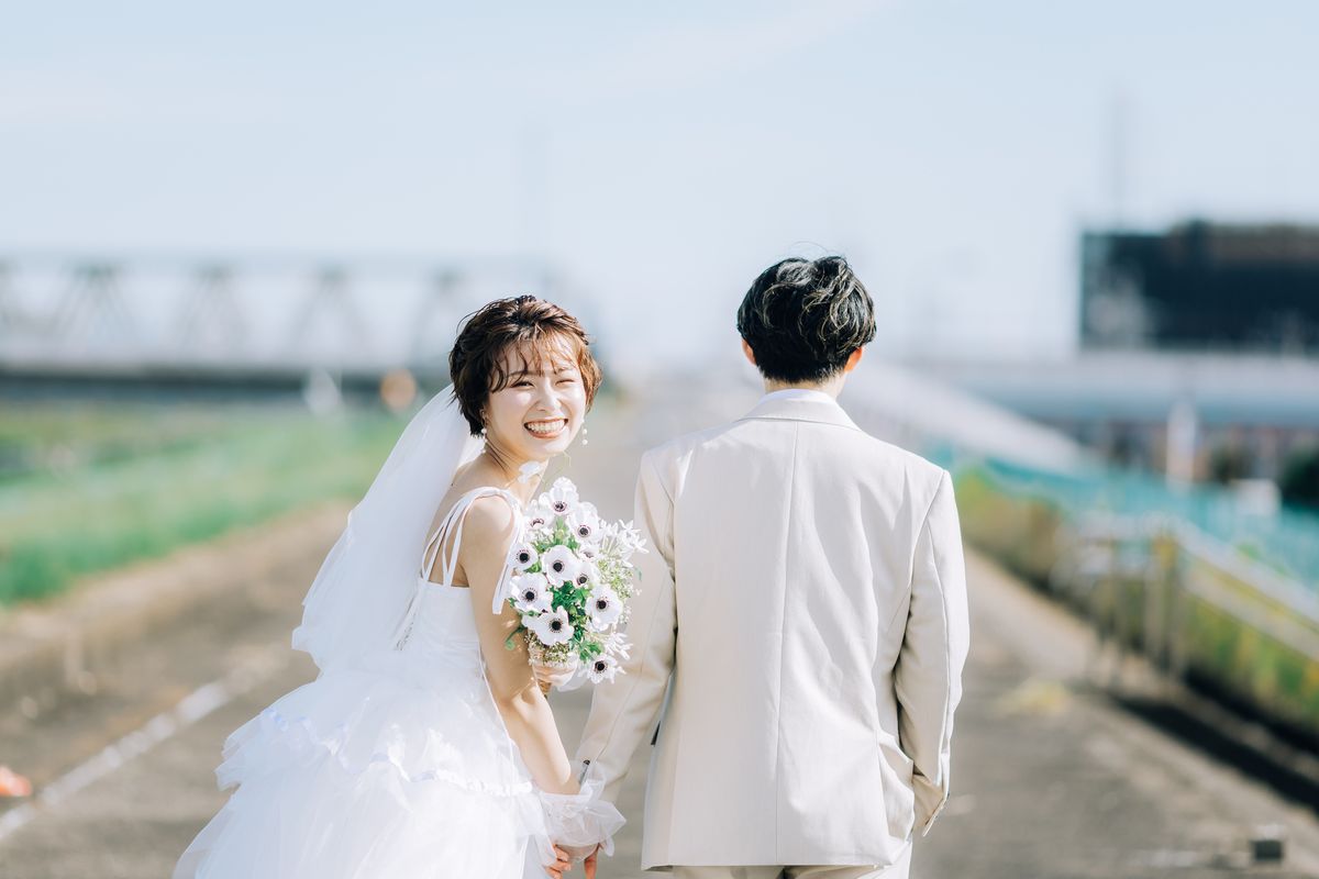 振り返って微笑む新婦と、並んで歩く新郎